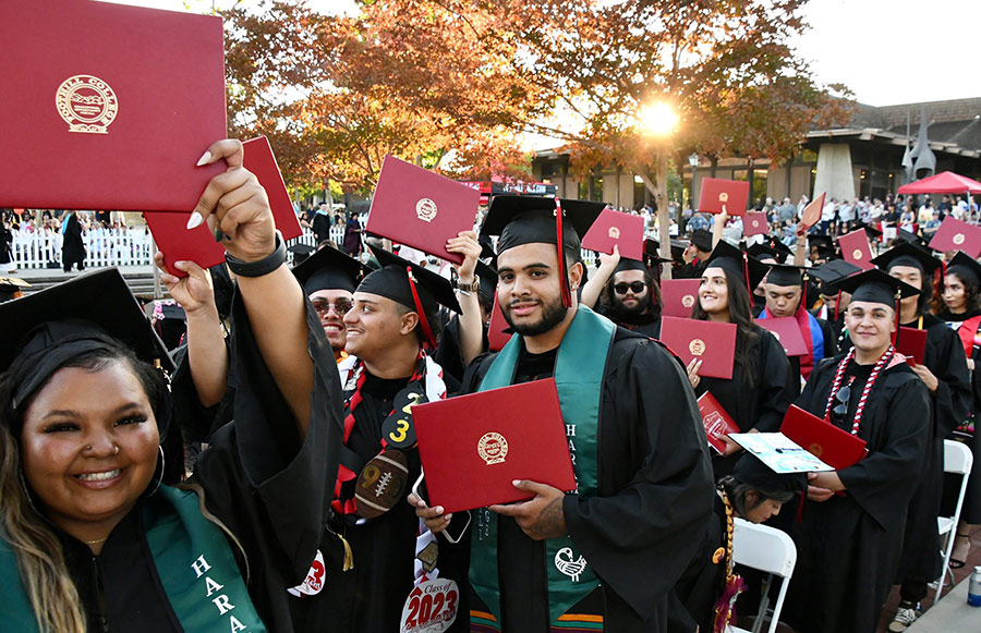 A group of graduates holding degree covers