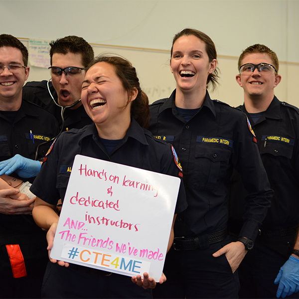 Diverse group of Paramedics showing a poster about hands on learning