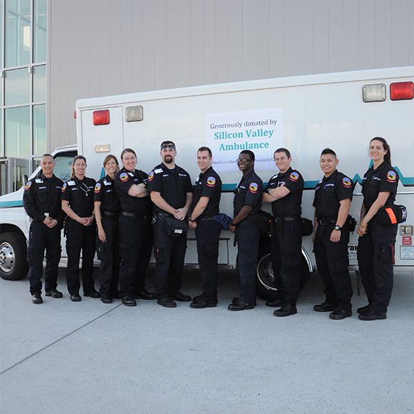 Divers group of paramedic students in front of an ambulance 