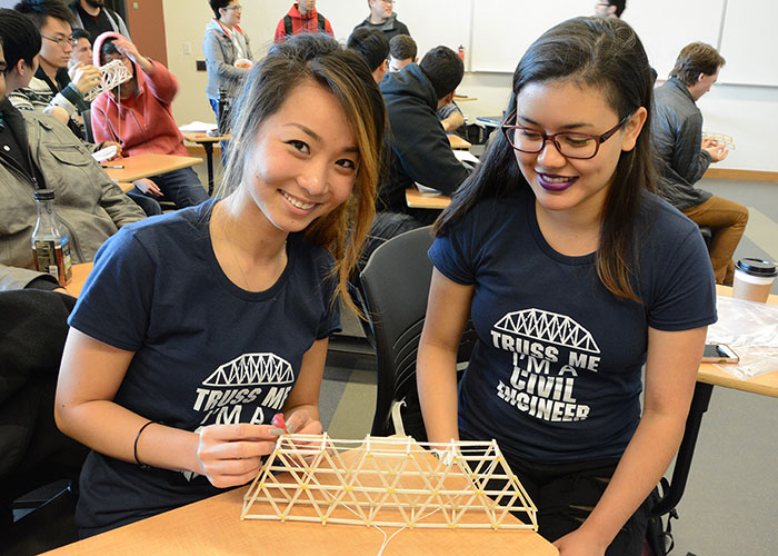 Two female engineering students working on a bridge project