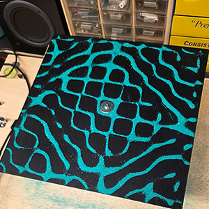 Chladni plate experiment showing cymatic sound wave patterns forming geometric shapes in sand.