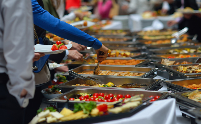 Image of a person putting food from serving bowl