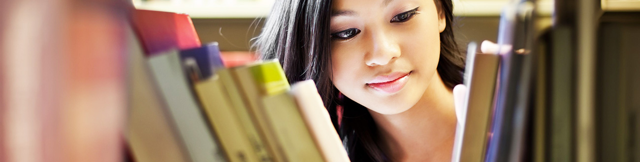 female student looking through books