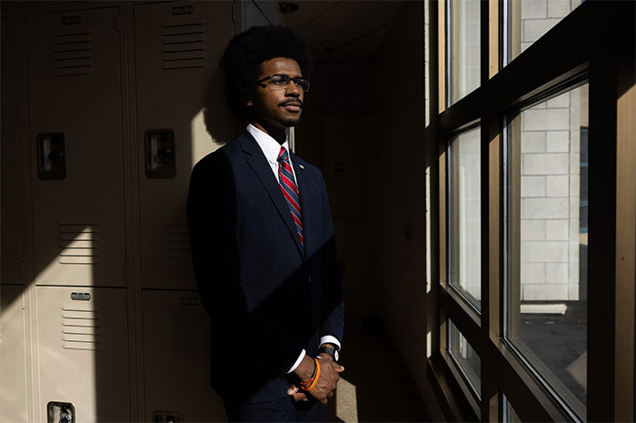 Portrait of black man in suit looking pensively outside window