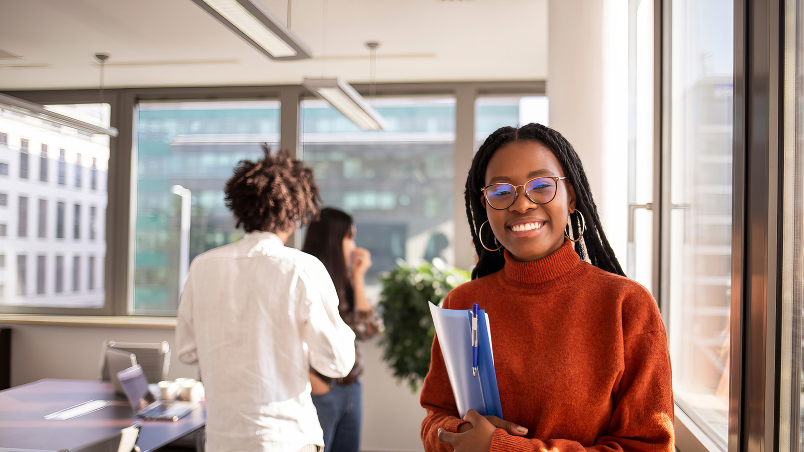 Female black student smiling with notebooks on the hands 