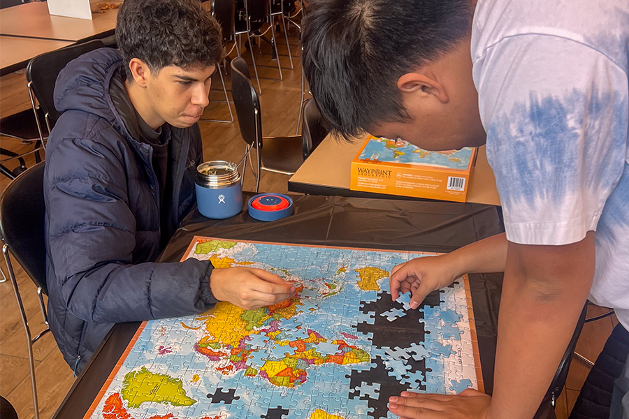 Two male students making a map puzzle 