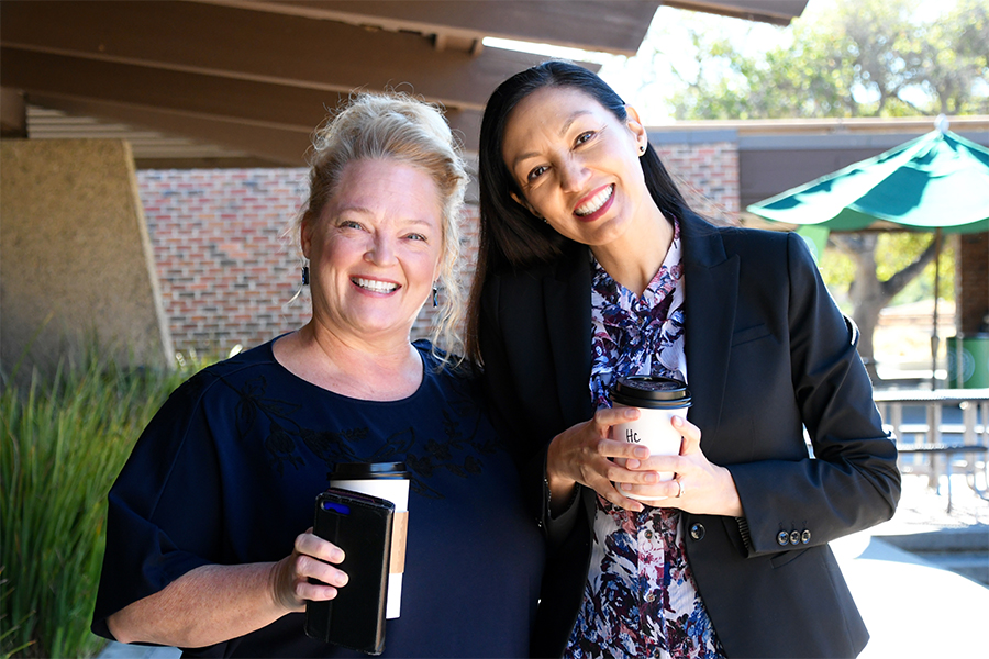 Faculty and Staff members smiling with a coffee glass 
