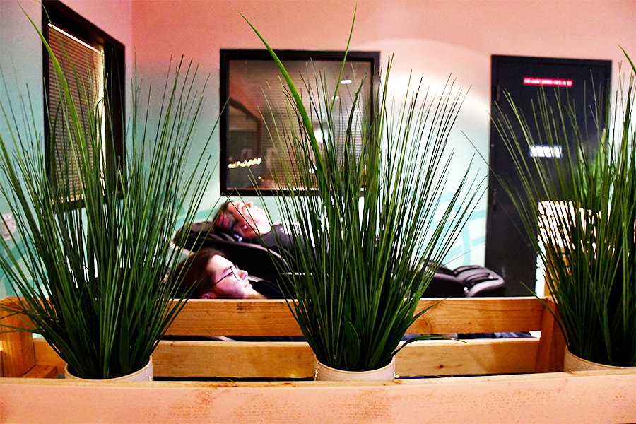 Two students enjoying the massage seats at the wellness lounge