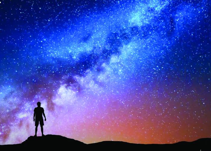 Night sky with stars with human silhouette on ground