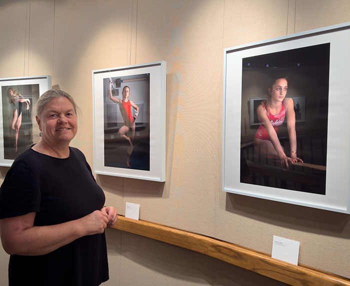 Judy Walgren in the KCI gallery with three photographs on wall