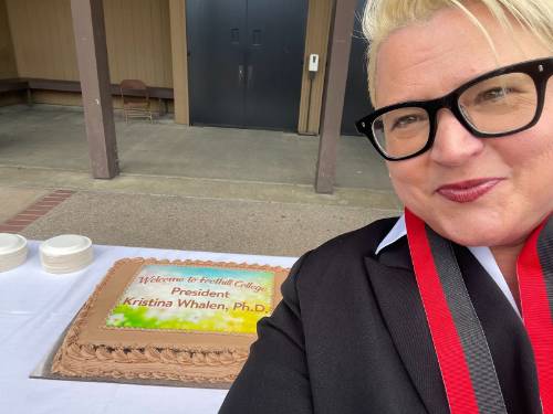 Kristina Whalen in front of a cake with a green image