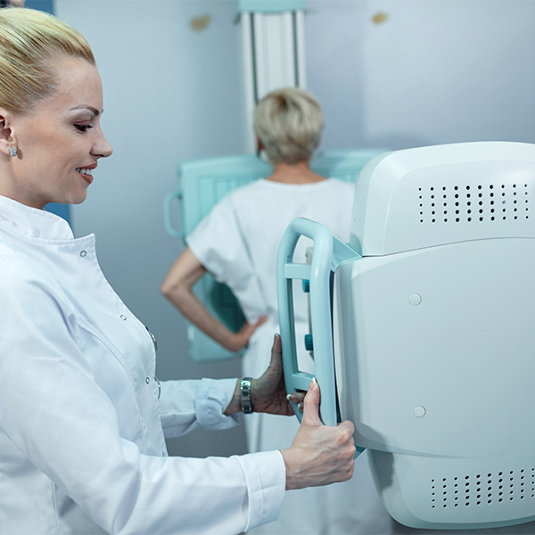 mid adult smiling nurse taking xray patient clinic