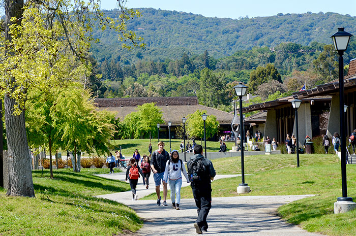 outdoor area with students walking with hill in background