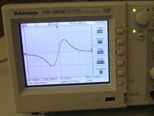 Photo of a waveform.  It starts small, goes through a peak, and then forms an inverted mirror image.