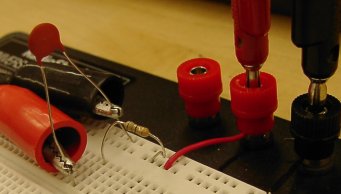 photo of the circuit.  Power comes in from the function
generator, flows through the resistor, and then the capacitor, back to the function generator.  The voltage is measured across
the capacitor.