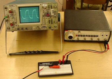 photo of all of the equipment, a function generator, an oscilloscope and a breadboard with resistors and capacitors