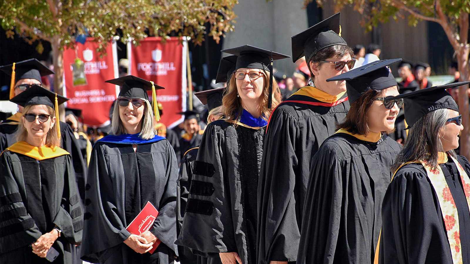 Faculty in academic regalia processing during a commencement ceremony, celebrating graduation day.